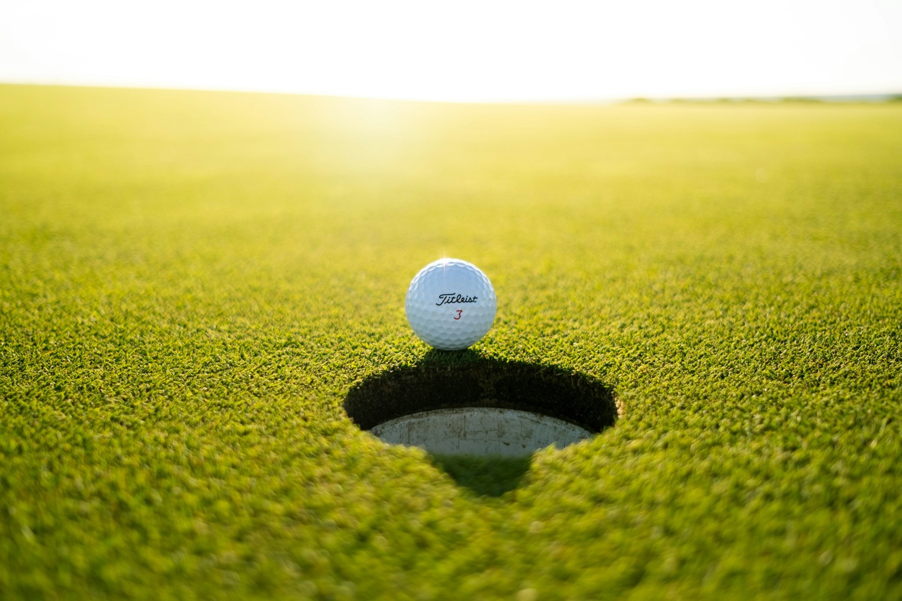 Junior golfer practicing on a course at sunrise